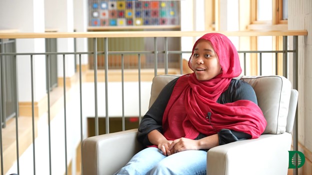 Student speaking in a chair. 